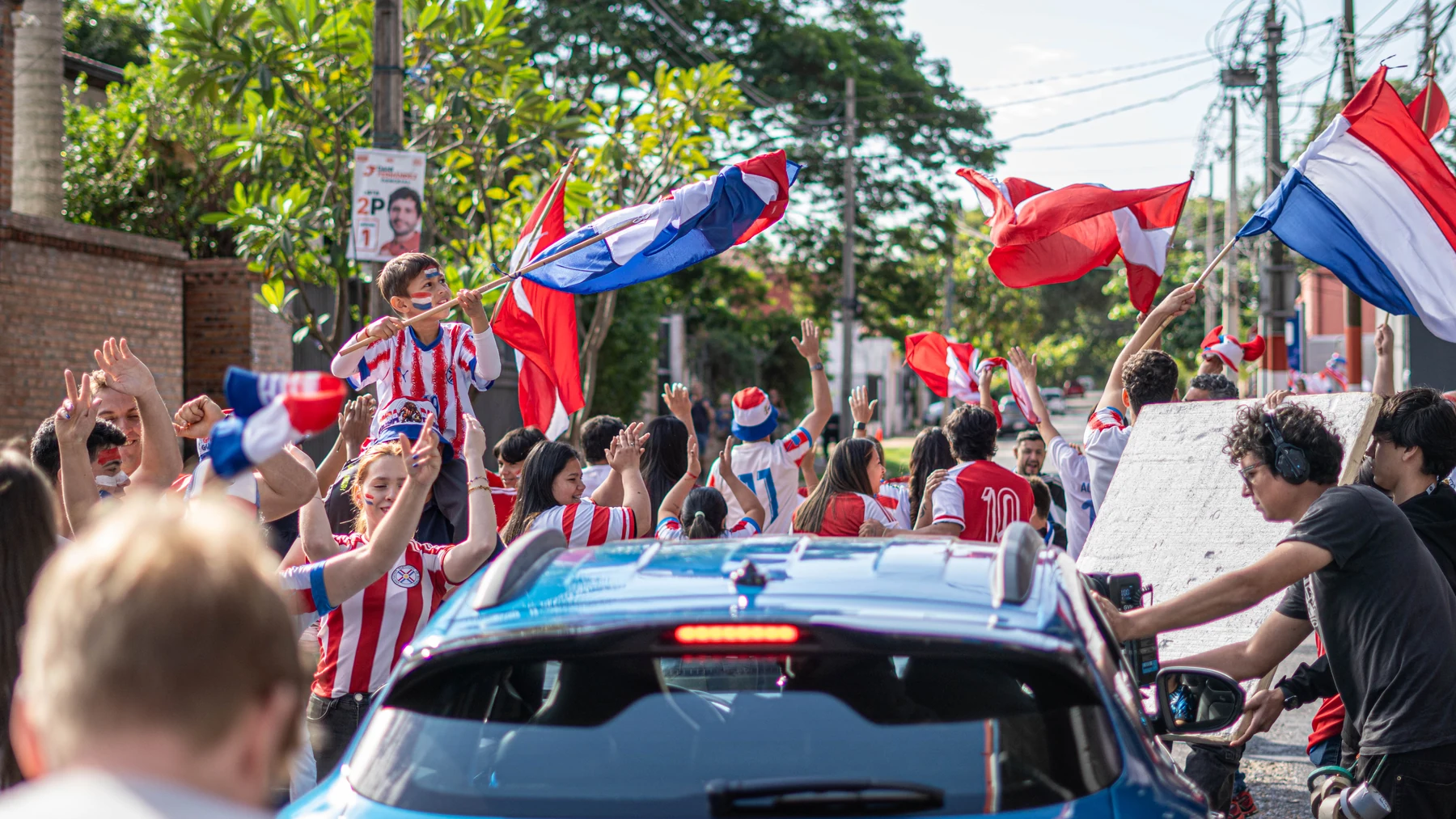 La hinchada con banderas paraguayas celebrando alrededor del VW Tera